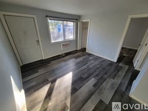 La Crosse apartment for rent - A room with wooden flooring and a window with blinds.