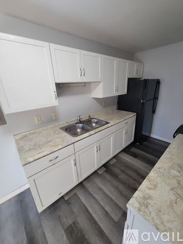 La Crosse apartment for rent - A kitchen with white cabinets and a black refrigerator.