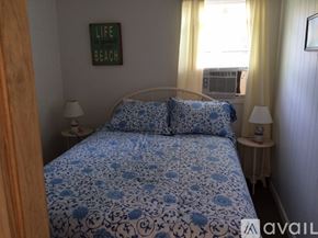 South Kingstown house for rent - A bedroom with a bed, two lamps, and a framed picture on the wall.