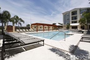 St. Petersburg apartment for rent - A pool area with sun loungers and a building in the background.
