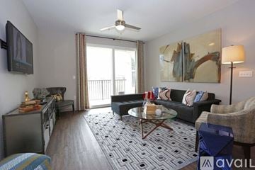 St. Petersburg apartment for rent - A living room with a black couch, a coffee table, and a painting on the wall.