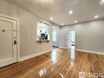Elizabeth apartment for rent - A room with wooden floors and white walls, with a door on the left and a window on the right.