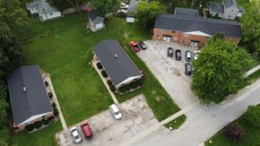 Millbury apartment for rent - A parking lot with cars and a building in the background.