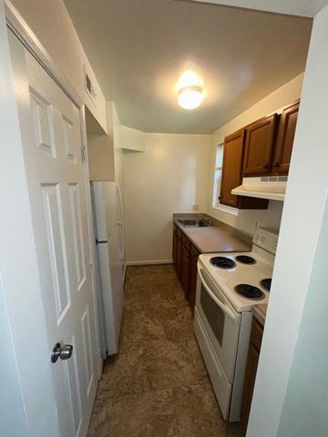 Washington apartment for rent - A kitchen with a stove top oven and a refrigerator.