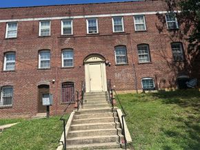 Washington apartment for rent - A red brick building with a white door and windows.