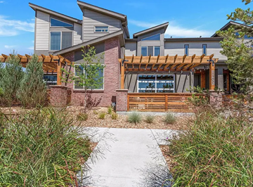 Wheat Ridge house for rent - A modern house with a wooden pergola and a concrete pathway leading to the entrance.