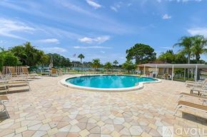 Sarasota condo for rent - A pool surrounded by sun loungers and a clear blue sky.