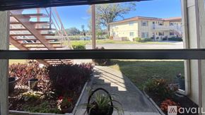 Sarasota condo for rent - A view from a window looking out to a building and a landscaped garden.