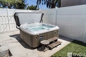 Los Angeles house for rent - A hot tub is surrounded by a white fence and has a wooden deck.