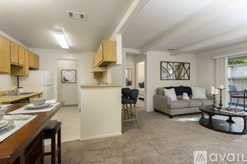 Modesto apartment for rent - A living room with a couch, chair, and a dining table with chairs.