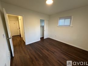 Tacoma townhouse for rent - A room with wooden floors and white walls, with a window on the right wall.