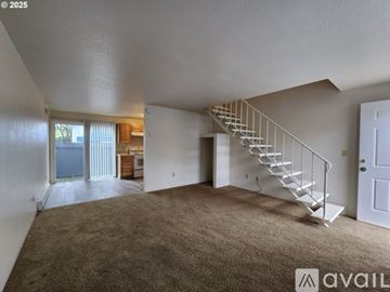Corvallis apartment for rent - A spacious room with a staircase leading to another floor.