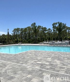 Englewood house for rent - A large outdoor swimming pool surrounded by trees and lounge chairs.