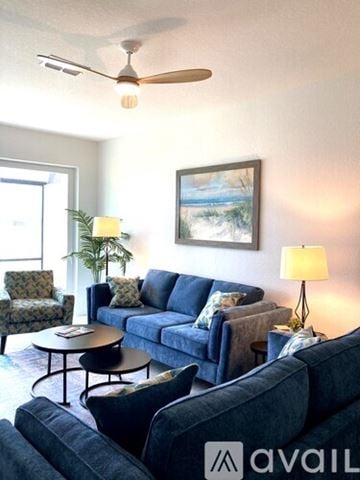 Englewood house for rent - A living room with a blue couch and a painting on the wall.