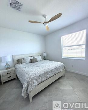 Englewood house for rent - A bedroom with a bed, nightstand, and window.