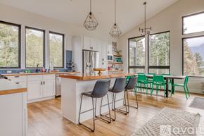 Stevenson house for rent - A kitchen with white cabinets and a wooden island with bar stools.