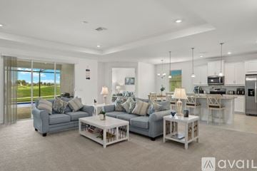 Naples house for rent - A modern living room with a grey sofa set and a kitchen area in the background.