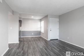 Yukon apartment for rent - A spacious room with wooden flooring and white walls.