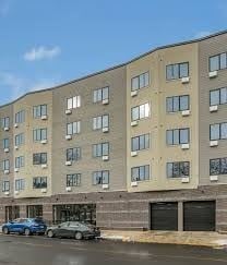 Newark apartment for rent - A large building with a parking lot in front of it.