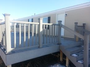 Billings house for rent - A wooden deck with a railing and steps leading to a house.