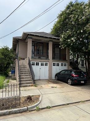 New Orleans apartment for rent - A black car is parked in front of a white garage door.