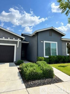 Merced house for rent - A modern house with a grey exterior and a white garage door.
