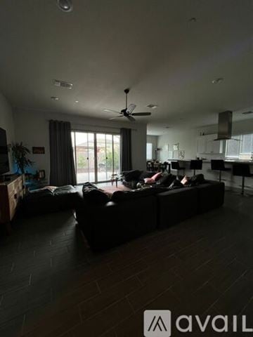 Merced house for rent - A living room with a black couch and a ceiling fan.