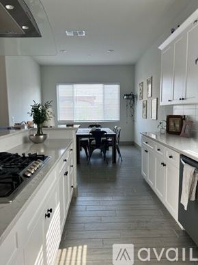 Merced house for rent - A kitchen with white cabinets and a black stove top.