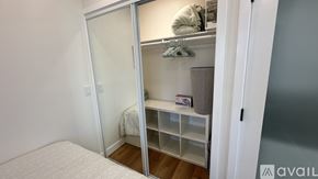 Santa Ana apartment for rent - A bedroom with a white bed and a white closet with a mirror.