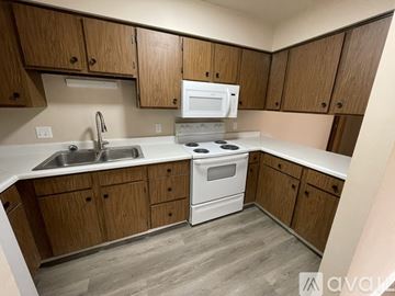 Montrose apartment for rent - A kitchen with wooden cabinets and white appliances.