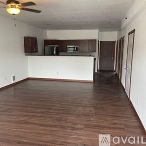 Sparta townhouse for rent - A spacious living room with wooden flooring and a kitchen area in the background.