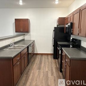 Sparta townhouse for rent - A kitchen with wooden cabinets and black appliances.
