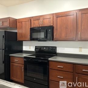 Sparta townhouse for rent - A kitchen with black appliances and wooden cabinets.