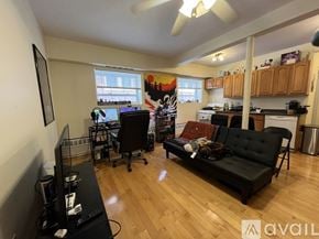 Brookline apartment for rent - A living room with a black couch and a television.