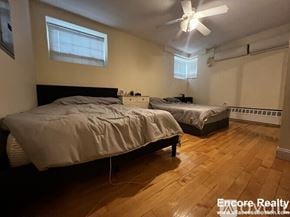 Brookline apartment for rent - A bedroom with two beds and a ceiling fan.