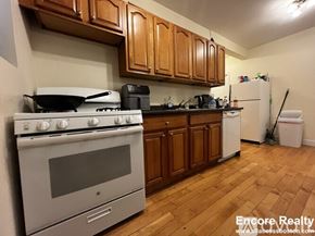 Brookline apartment for rent - A kitchen with a stove, oven, and wooden cabinets.