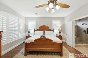 Lewisville house for rent - A bedroom with a large bed and a ceiling fan.