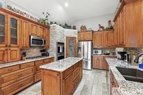 Lewisville house for rent - A kitchen with wooden cabinets and a marble countertop.