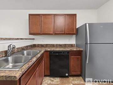 Stonecrest apartment for rent - A black stove top oven in a kitchen with brown cabinets.