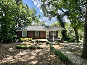 Columbia house for rent - A small house with a porch surrounded by trees.