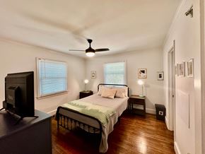 Columbia house for rent - A bedroom with a bed, a television, and a ceiling fan.