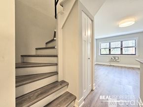 Chicago condo for rent - A spacious room with wooden flooring and a window with blinds.