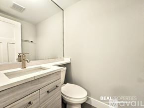 Chicago condo for rent - A spacious room with wooden flooring and a window with blinds.