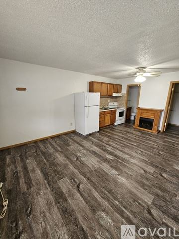 La Crosse apartment for rent - A kitchen area with a white refrigerator and wooden cabinets.