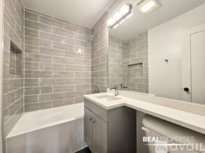 Chicago condo for rent - A spacious room with wooden flooring and two windows with blinds.