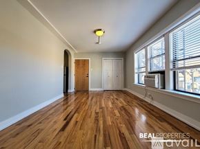 Chicago condo for rent - A bathroom with a toilet, sink, and mirror.