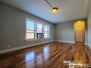 Chicago condo for rent - A bathroom with a toilet, tub, and a window.
