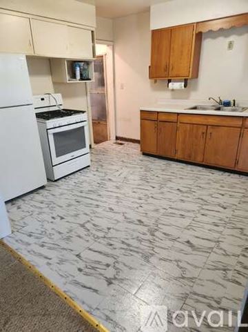 Muncie house for rent - A kitchen with wooden cabinets and a sink.