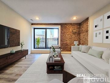 Chicago condo for rent - A living room with a white couch and a brick wall.