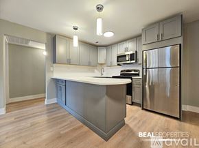Chicago condo for rent - A bedroom with a large bed and a green dresser.